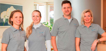 group of four people standing and smiling